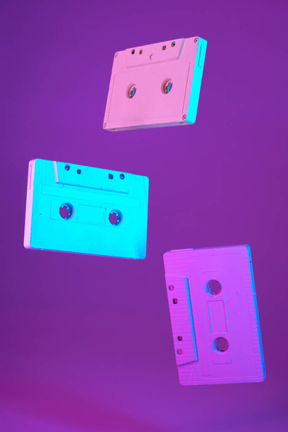 Cassette tape vintage style suspended in air on purple background - Foto, afbeelding