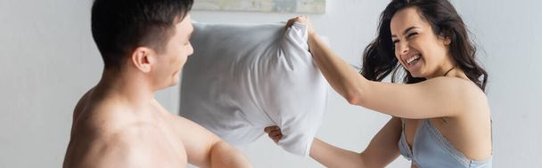 happy and sexy couple having pillow fight in bedroom, banner - Foto, Bild