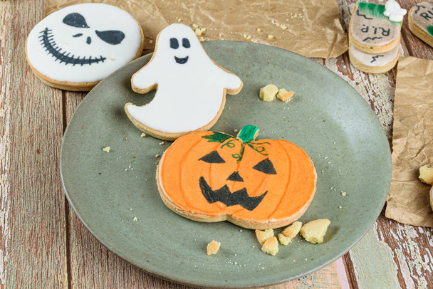 Pumpkin and ghost-shaped buttery cookies on a green plate. - Photo, Image