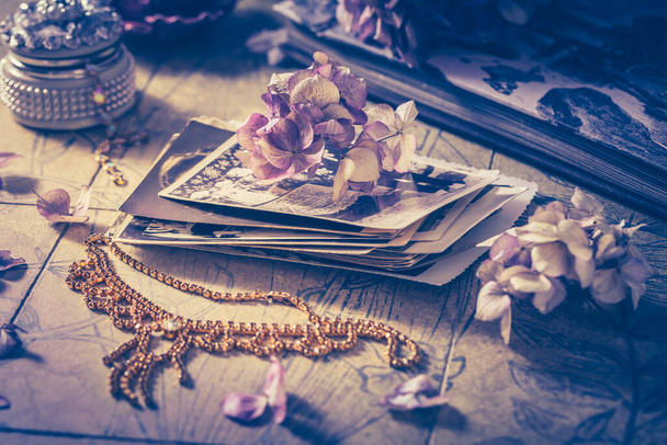Vzpomínky - staré rodinné fotoalbum s náhrdelníkem, starými knihami a sušenými květinami a svíčkami - Fotografie, Obrázek