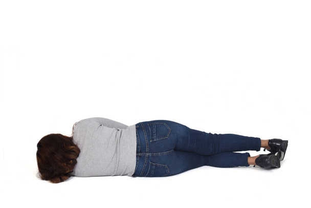 vista posteriore di una donna sdraiata sul pavimento su sfondo bianco - Foto, immagini