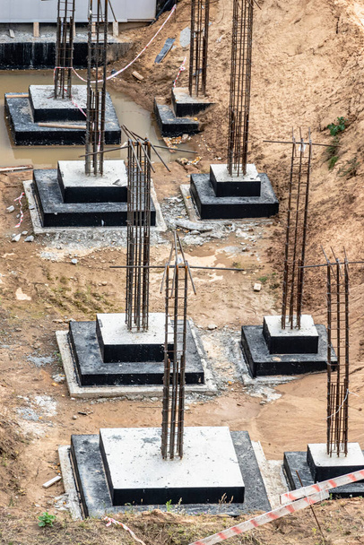 Fundamentos monolíticos de hormigón armado para la construcción de un edificio residencial. Parrilla en el sitio de construcción. Fosa de construcción con cimientos - Foto, Imagen