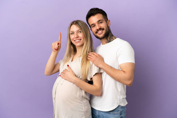 Молода пара вагітна і вказує
 - Фото, зображення