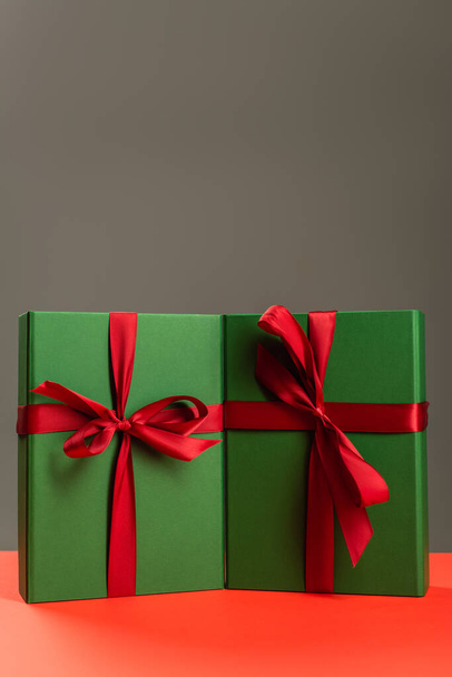 cadeaux enveloppés vert sur surface rouge isolé sur gris  - Photo, image