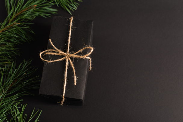 Kara desenli köknar dallarının yakınındaki hediye kutusunun üst görünümü - Fotoğraf, Görsel
