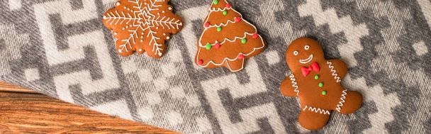 vista dall'alto dei biscotti di pan di zenzero sulla coperta grigia con ornamento, banner - Foto, immagini