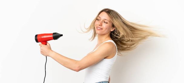 Woman with a hairdryer over isolated background - Photo, Image