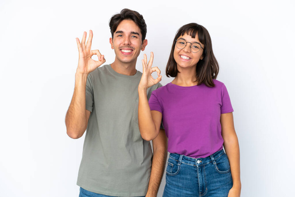 Junges Paar isoliert auf isoliertem weißen Hintergrund zeigt ein ok Zeichen mit den Fingern - Foto, Bild