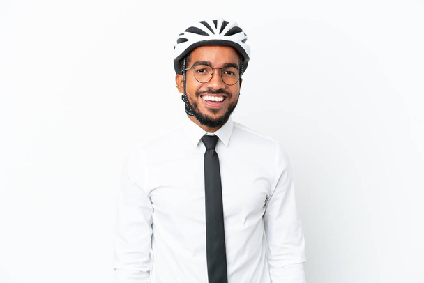 Young business latin man holding a bike helmet isolated on white background laughing - Photo, Image