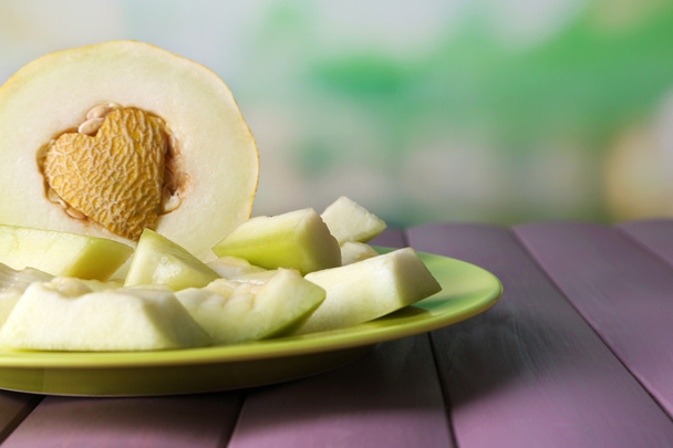 Slice of melon on green plate on wooden table on natural background - Photo, image