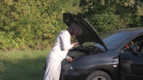 Une femme compose un numéro de téléphone après une panne de voiture. Problèmes de voiture. - Séquence, vidéo