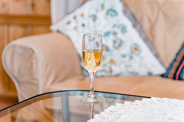 Een glas champagne op tafel. Sprankelend drankje in een rustiek interieur. - Foto, afbeelding