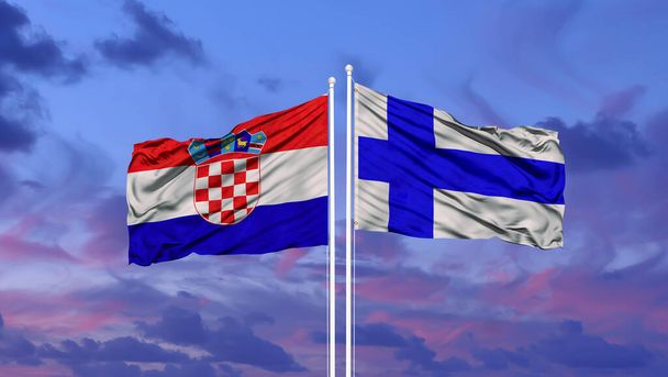 Finland en Kroatië vlag zwaaien in de wind tegen witte bewolkte blauwe hemel samen. Diplomatie concept, internationale betrekkingen - Foto, afbeelding