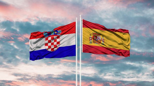 Spanje en Kroatië twee vlaggen op vlaggenmasten en blauwe bewolkte lucht - Foto, afbeelding