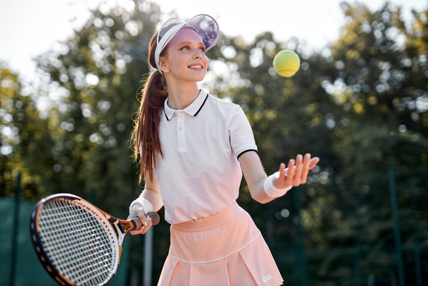 Backhand. Cheerful well-developed, professional movement of female tennis player - Foto, imagen