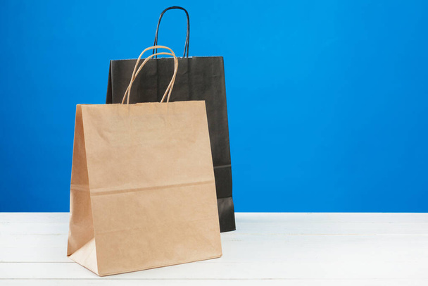 Arrangement of shopping bags on blue background - Fotó, kép