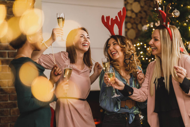 Filles multietnic joyeux s'amuser tout en trinquant avec du champagne à Noël ou la fête du Nouvel An ensemble. - Photo, image