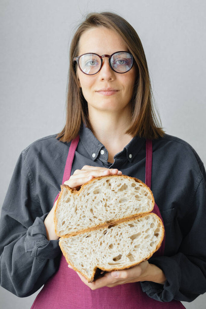 yeast-free sourdough bread. a beautiful European woman baker holds bread in her hands - Фото, зображення
