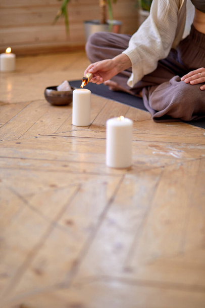 close-up hands Burning palo santo for home purification and meditation, sitting on mat - Fotó, kép