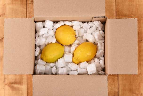 Lemon in a cardboard post box. - Φωτογραφία, εικόνα