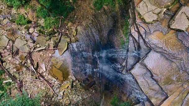 Вид вниз на край водопада в ущелье - Фото, изображение