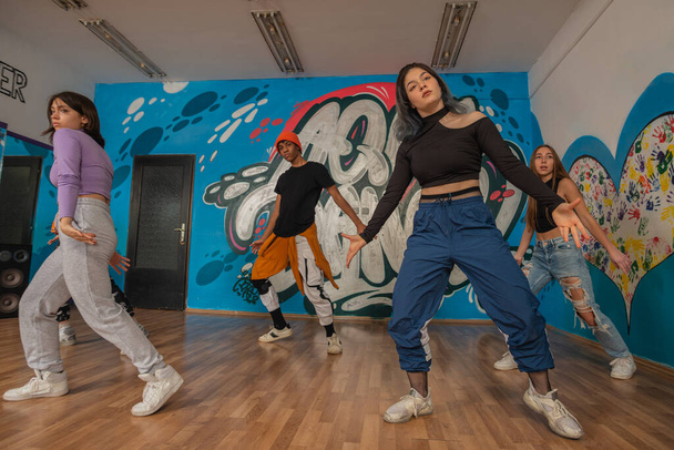 mladí tanečníci v pestrobarevných šatech se baví tancováním hip-hopu, užívají si být aktivní. životní styl, generace mládeže - Fotografie, Obrázek