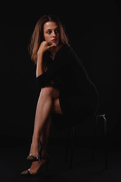 Siyah topuklu ve kısa etekli şık bir kadının vücut fotoğrafı. - Fotoğraf, Görsel