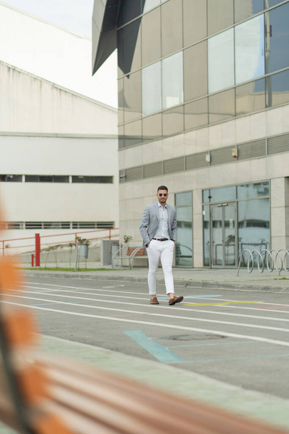 Handsome businessman is walking in front of the company alone - Photo, image