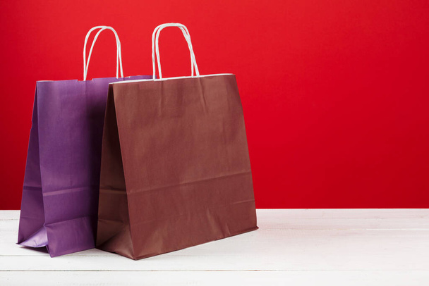 Several shopping bags with copy space on red background - Fotó, kép