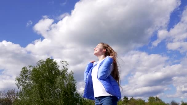 Sonbahar ceketli mutlu genç kız gökyüzünde güneşin tadını çıkar, motivasyon - Video, Çekim