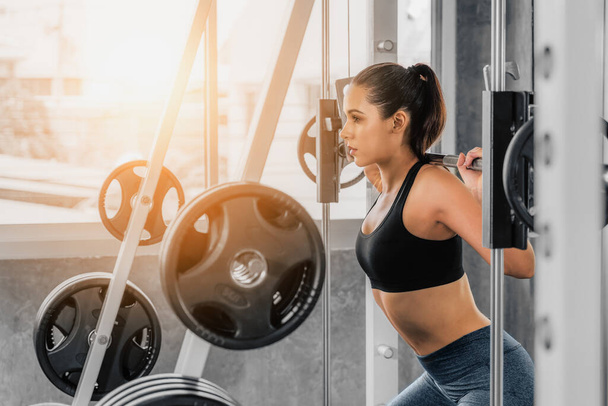 caucasian athletic sport woman in sportswear exercising with barbell lifting for bodybuilding in gym and fitness club for wellbeing lifestyle with light flare - Φωτογραφία, εικόνα