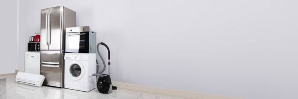Set Of Household Kitchen Electronics Appliances On Reflective White Floor Against Wall - Foto, Bild