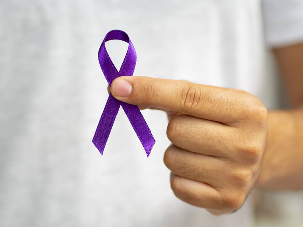 close up person holding up purple ribbon. High quality beautiful photo concept - Fotografie, Obrázek