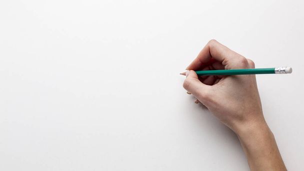 top view hand holding pencil with copy space. High quality beautiful photo concept - Photo, Image