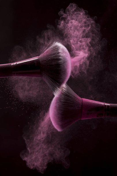 cepillos cosméticos polvo de niebla rosa fondo oscuro. concepto de foto hermosa de alta calidad - Foto, imagen