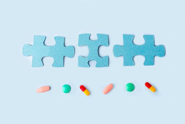 Blue jigsaw puzzle pieces with different pills and medicines. Concept of Neurological Disease Treatment : Autism, Alzheimer's, Dimension. Copy space for text. Awareness day. Supportive and Acceptance - Photo, image