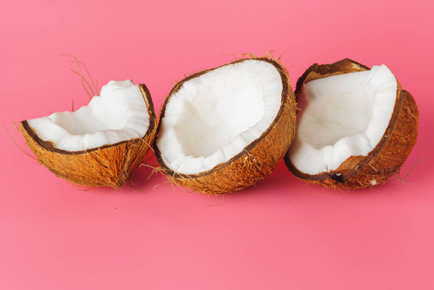 Coconut halves on a bright pink background - Фото, зображення