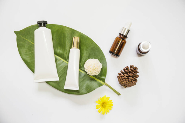 spa cosméticos produto folha com óleo essencial pinecone flores fundo branco. Conceito de foto bonita de alta qualidade - Foto, Imagem