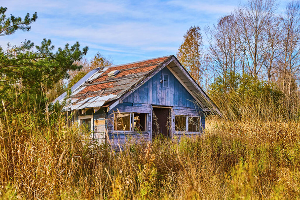Alte Hütte zerfällt auf Feld mit blauer Verkleidung - Foto, Bild