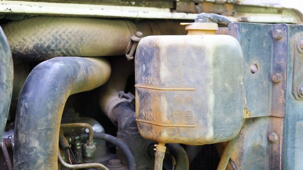 汚れた冷却タンクのクローズアップビュー。コピースペースと古いと汚れた車のエンジン水冷却システムのラジエータタンク。選択的焦点 - 写真・画像
