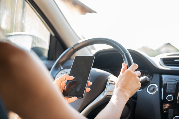 Frau benutzt Handy und SMS während der Autofahrt. - Foto, Bild