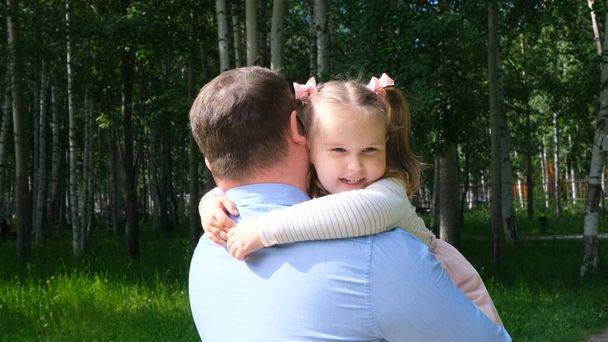 Pai feliz carregando em torno de seu pescoço e abraçando a filha 4-5 anos de idade enquanto caminhava no parque - Foto, Imagem