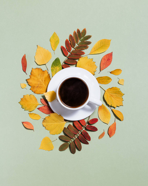 Autumn composition with cup of coffee and autumn leaves. Cozy atmosphere and hot black coffee. Minimal flat lay, autumnal concept. Copy space - Фото, изображение