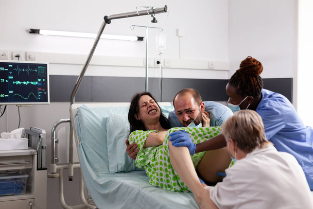 Pregnant person in labor with contractions giving birth - Photo, Image