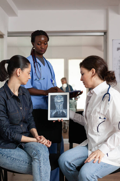 Facharzt für Radiologie analysiert klinische Röntgenaufnahmen mit Patientin - Foto, Bild