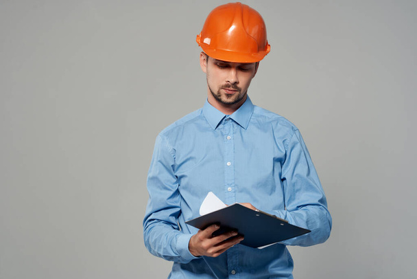 man in orange helmet blueprints builder isolated background - Фото, изображение
