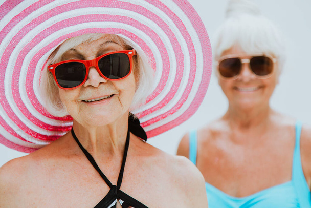 Happy senior women having party in the swimming pool - Elderly friends relaxing at a pool party - Fotografie, Obrázek