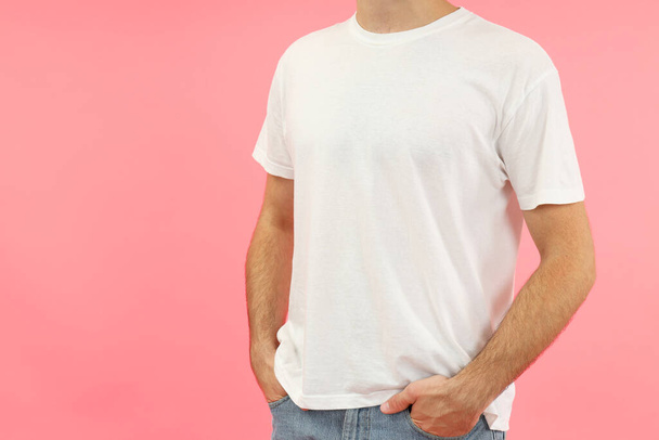 Hombre joven en camiseta blanca sobre fondo rosa. - Foto, imagen