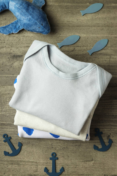 Conceito de roupas de bebê bonito no fundo texturizado cinza. - Foto, Imagem