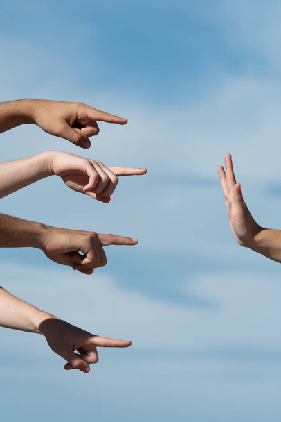 Manos señalando a una persona que hace el gesto de parar con la palma de la mano. Acusación y concepto de culpa. - Foto, imagen